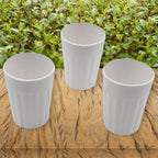 Plastic coffee and tea cups filled with a beverage, ready for serving.