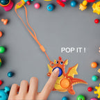 Hand pressing dual silicone bubbles on dragon push pop fidget toy