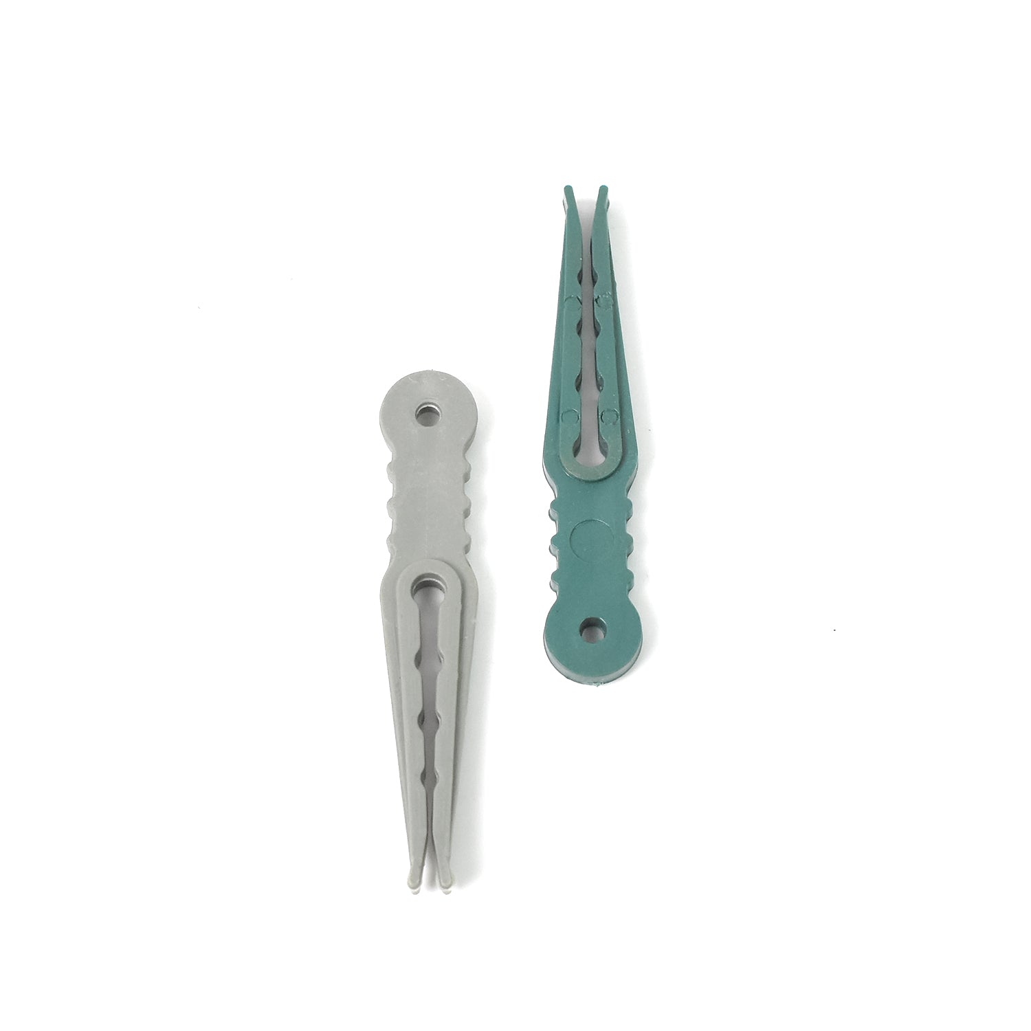 A hand demonstrating the strong grip of a plastic cloth peg on fabric.