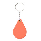 Hand holding portable folding magnifier keychain for reading small text