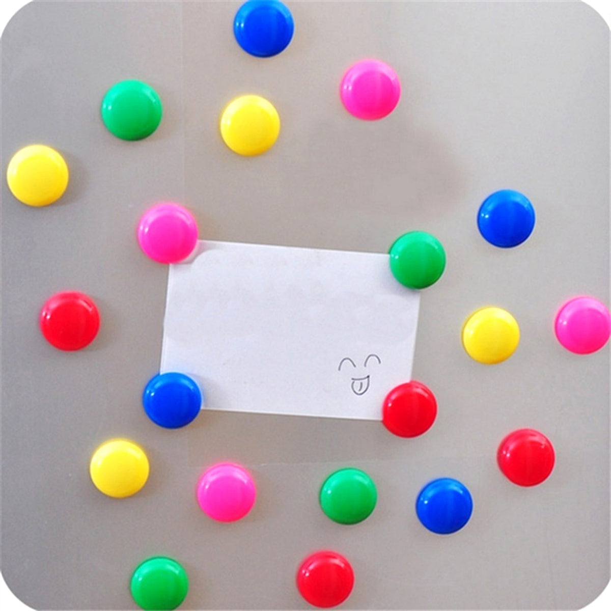 Colorful magnetic pins holding papers on a whiteboard in an office setting.