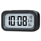 Backlit digital alarm clock displaying time at twilight