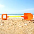 Kids shovel placed on garden sand surface for outdoor play activities
