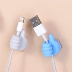 White hand clip firmly holding charging cables on desk