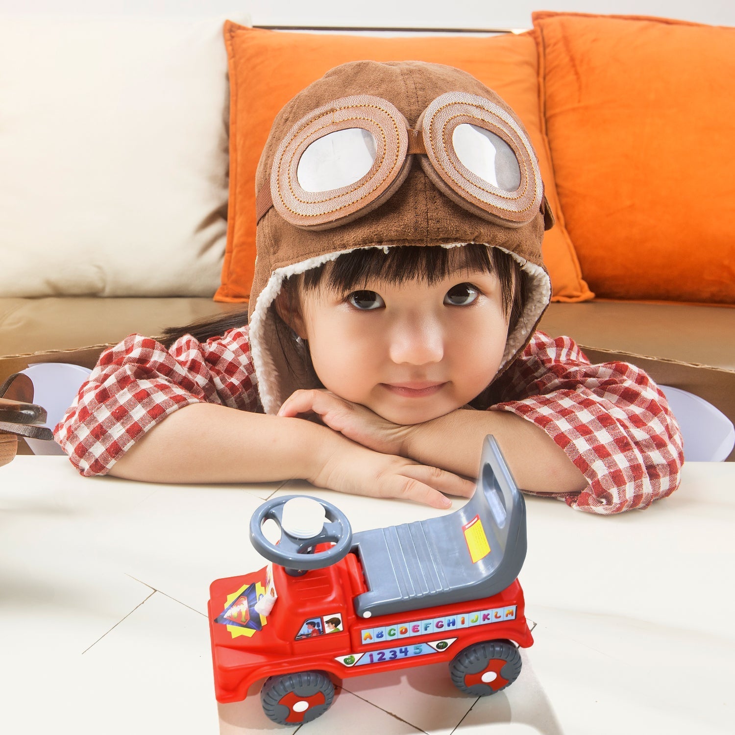 Child riding a colorful, safe ride-on toy with parents watching.