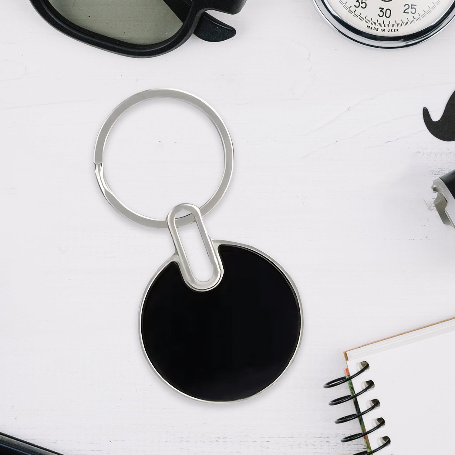 Black metal keychain closeup showing smooth finish and ring
