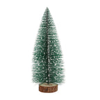 Decorative green artificial fir tree with snow effect standing on wooden base