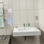 Strong plastic suction cup hook supporting towel on bathroom wall