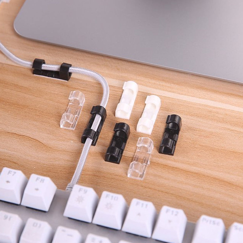 Plastic cable clips holding computer wires securely under a desk, improving office organization.
