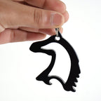 Horse head shaped metal keychain on white background