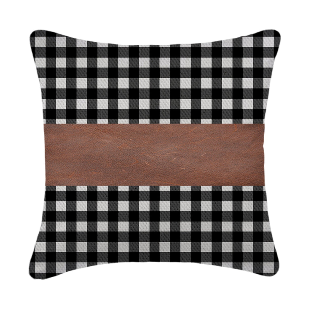 A set of contemporary leather pillow covers arranged on a comfortable armchair.