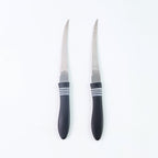 Serrated knife set placed on cutting board with vegetables for kitchen prep