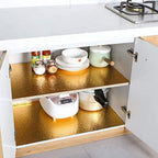 Golden oil-proof aluminum foil sticker installed on a kitchen wall.