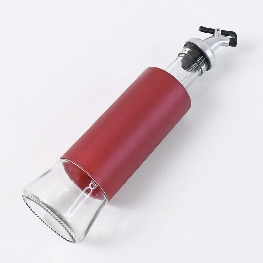 Glass oil and vinegar dispenser bottle with plastic covering and golden pour spout