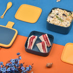 Ergonomic blue lunch box with a comfortable handle and dedicated slot for the spoon.