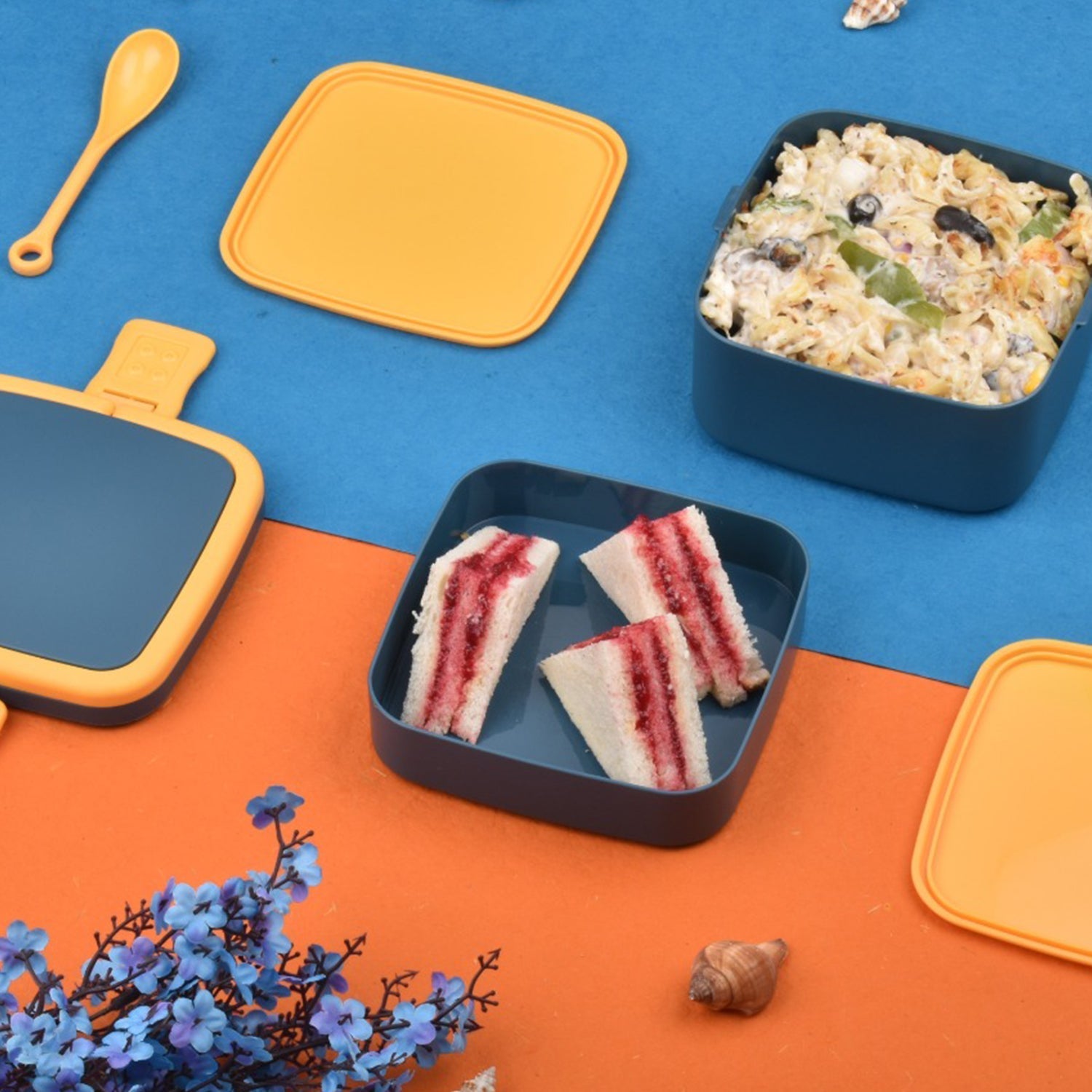 Ergonomic blue lunch box with a comfortable handle and dedicated slot for the spoon.