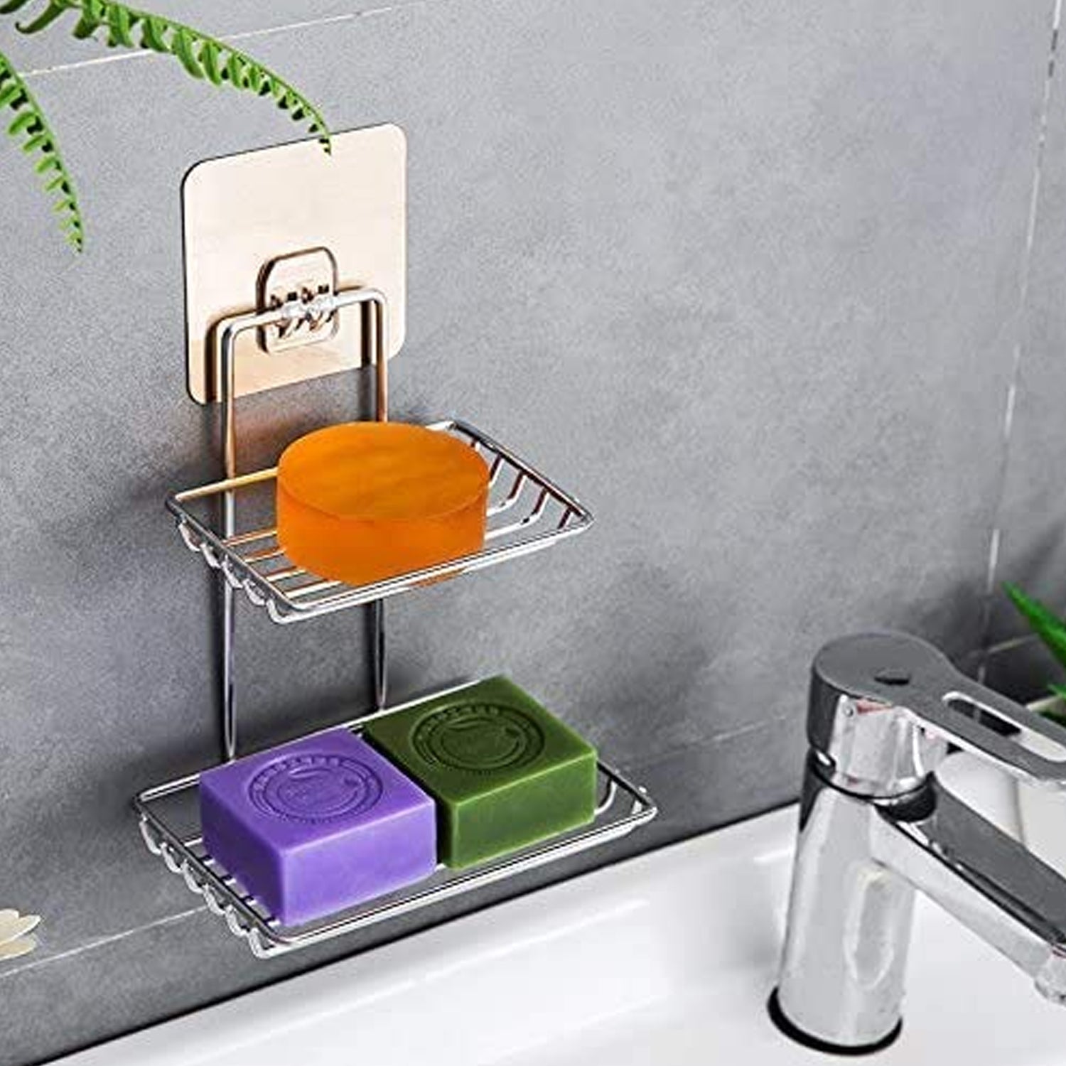 Stainless steel wall mounted soap dish with hooks installed above a kitchen sink.