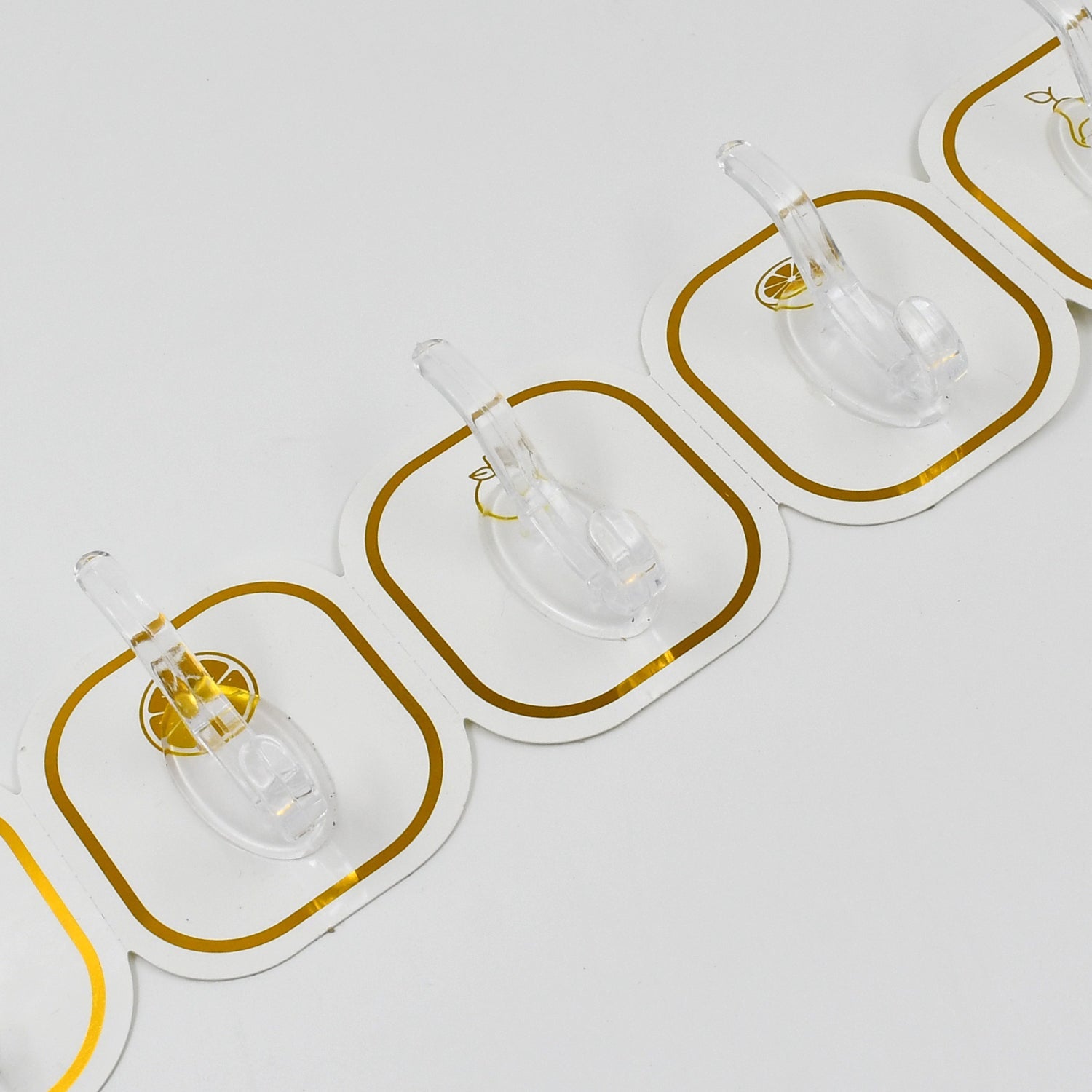 Transparent adhesive hooks installed on a white wall, blending seamlessly with home decor.