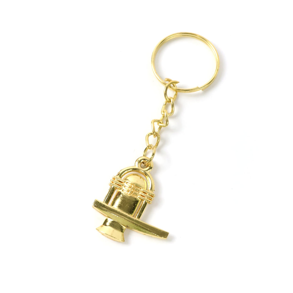 Golden Shivling metal keychain held in hand illustrating compact and lightweight design