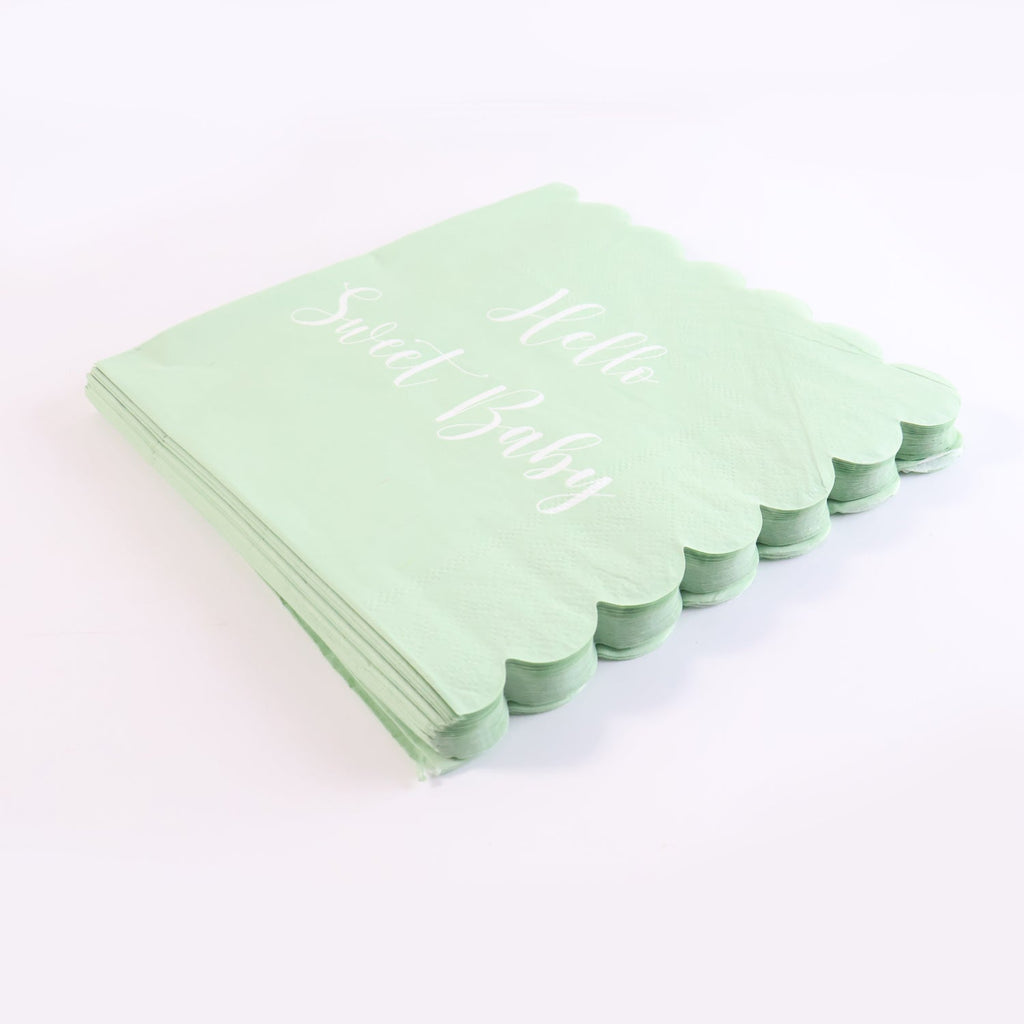 Tissue napkins with scalloped edges and baby party theme text in mint green