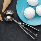 Top view of stainless steel kitchen scoop with spring-loaded release