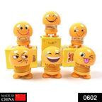 Front view of a funny bobblehead smiling face spring doll for desk decor.