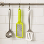 The ergonomic black plastic handle of the stainless steel grater, designed for a comfortable grip.