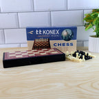 Foldable chess board displaying magnetic plastic pieces in play