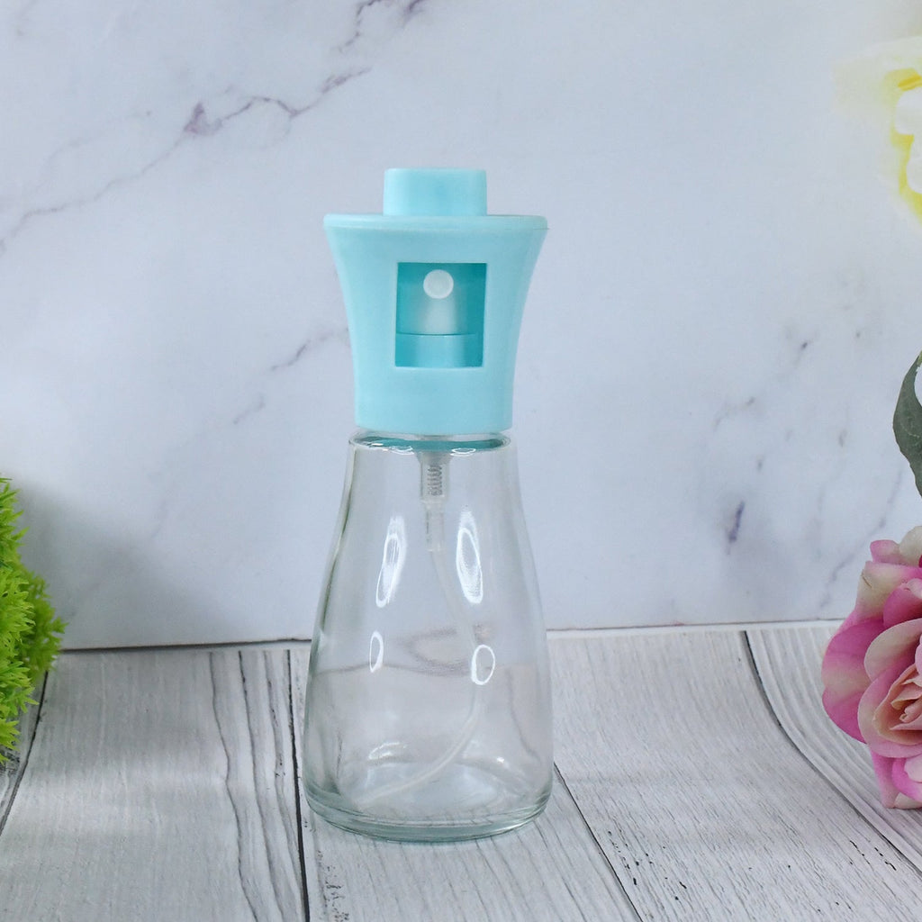 Efficient oil sprayer bottle being used to apply vegetable oil for a healthy meal.