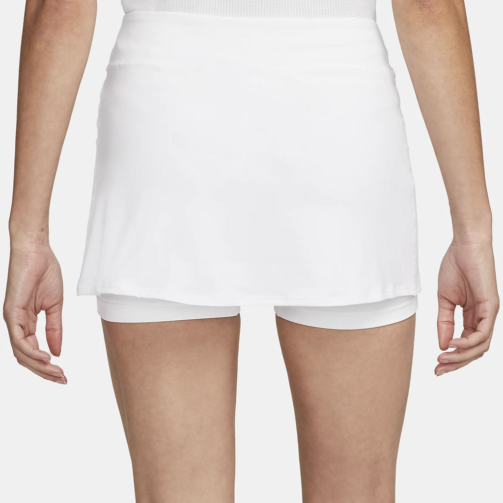 Model running in a white high-waisted athletic skort outdoors.