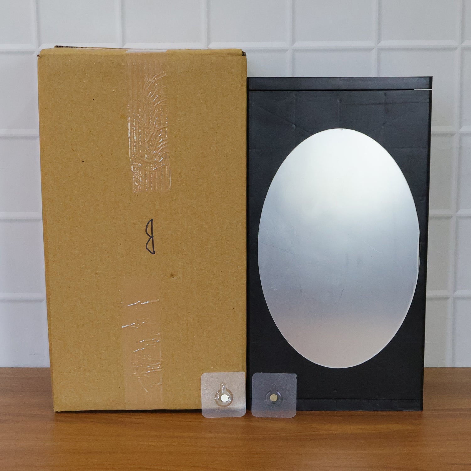 Stylish black wall-mounted storage box with front oval mirror for grooming essentials