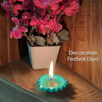 A hand gently places a colourful silicone diya for traditional Diwali decoration.
