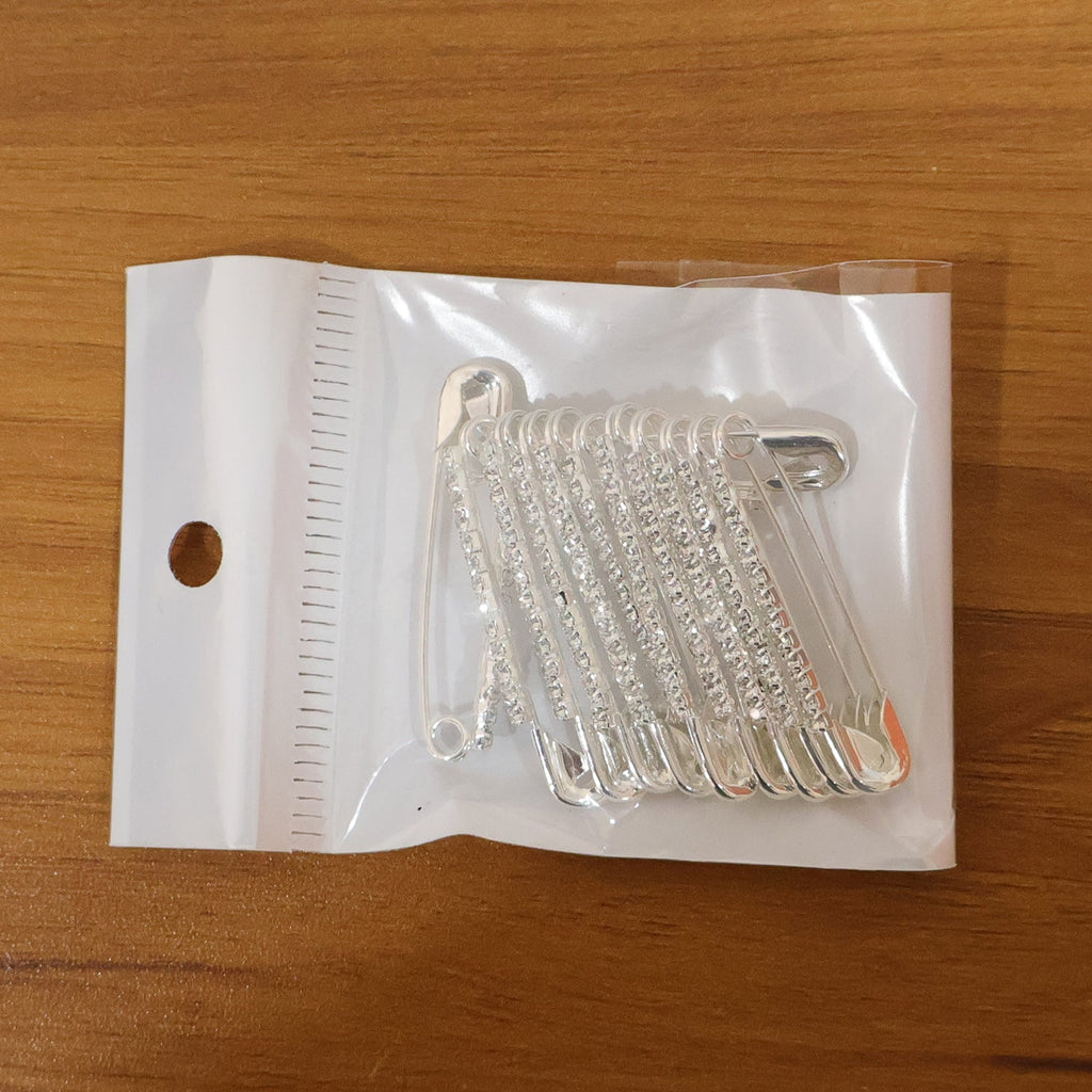 Size comparison of silver safety pin brooches from the 12-piece set