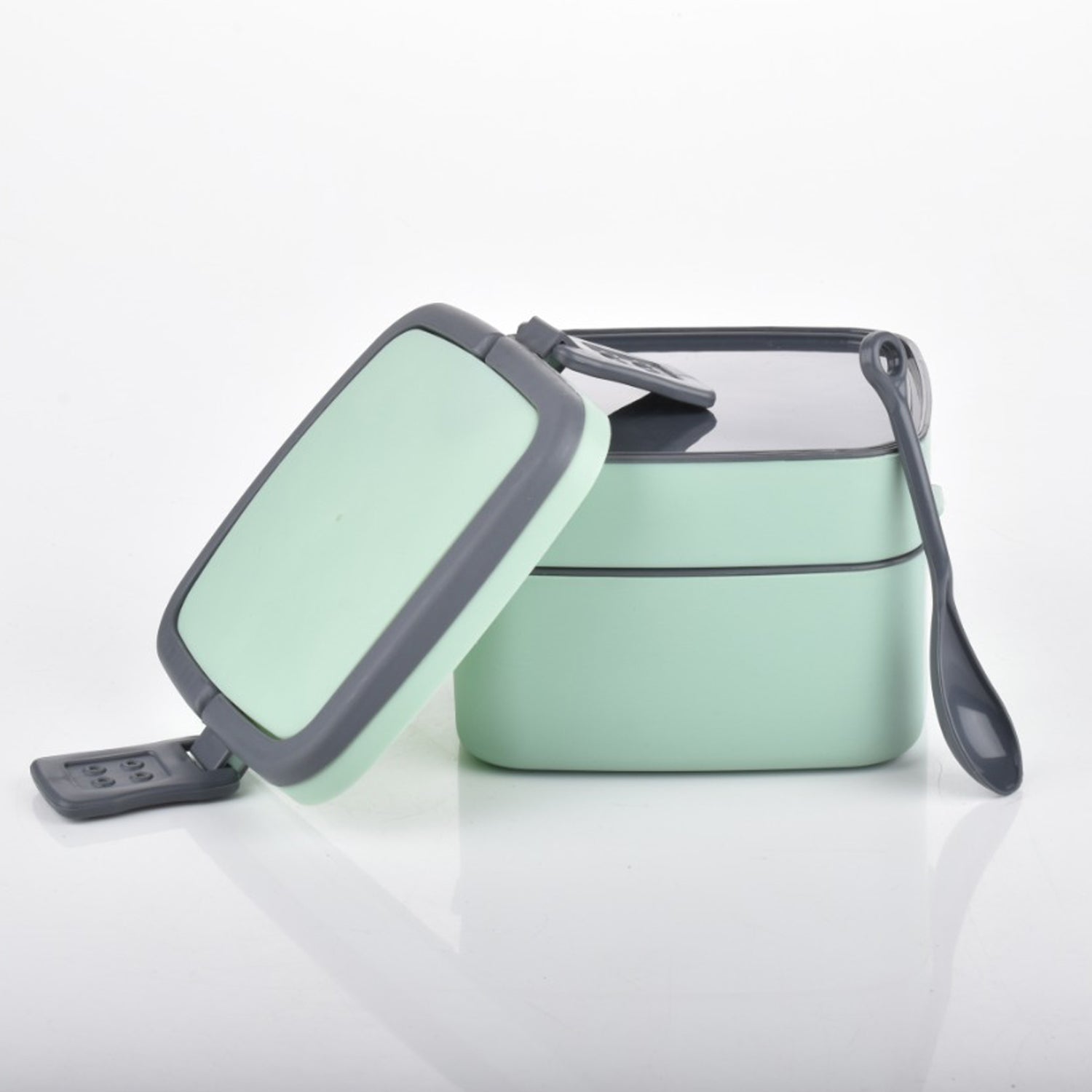 Stackable green lunch box with multiple compartments for varied meals.