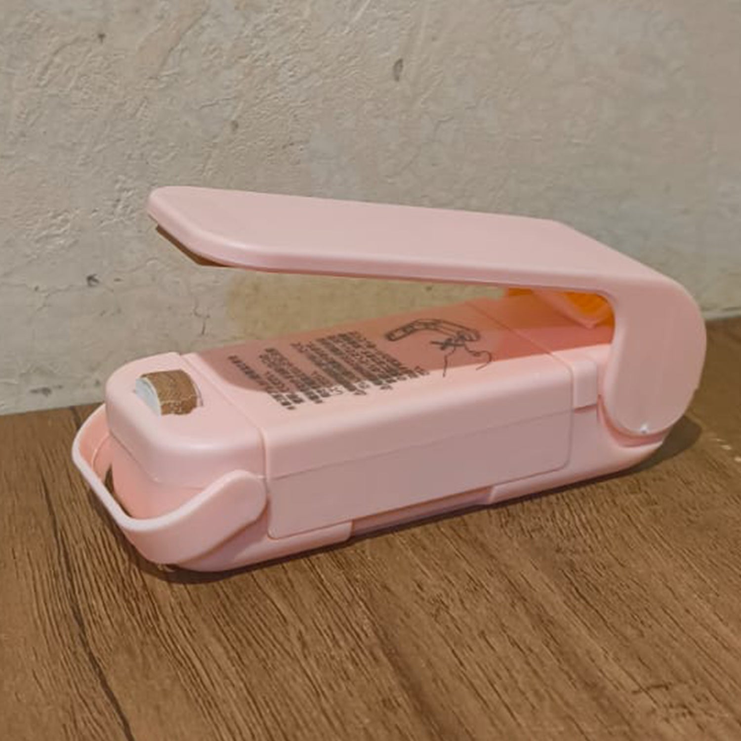 Hand holding the Mini Plastic Bag Sealer, highlighting its ergonomic design.