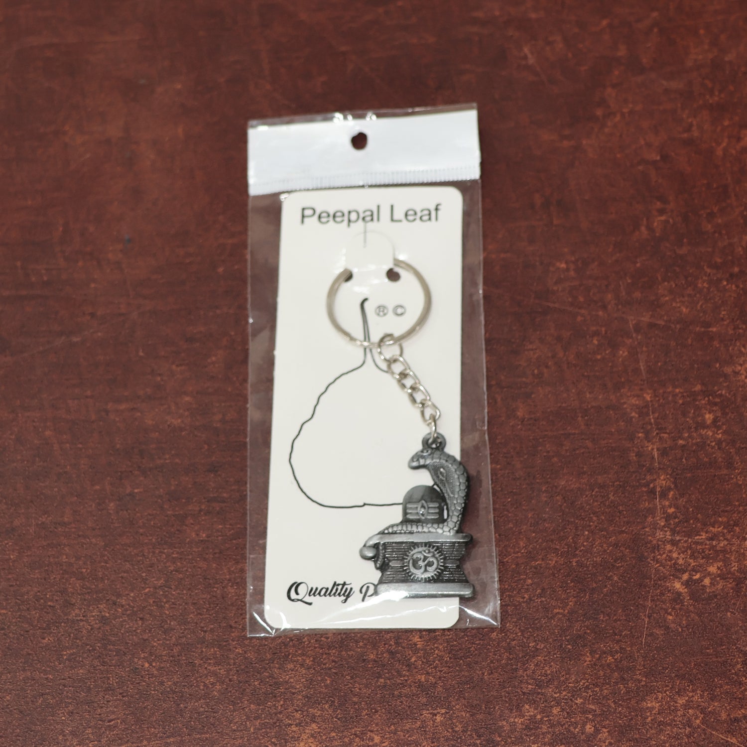 Display of durable metal Shivling keychain with snake design