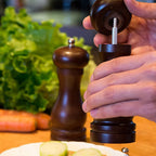 Artisan-crafted wooden pepper mill with an S-shaped design, perfect for any dining table.