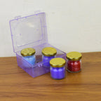 Close-up of wax candle contained in colorful glass jar with gold lid