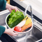 The stainless steel drain basket from the set, effectively straining washed vegetables or fruits.