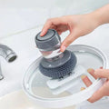 Ergonomic Soap Dispensing Dish Brush with clear soap reservoir for easy refilling.