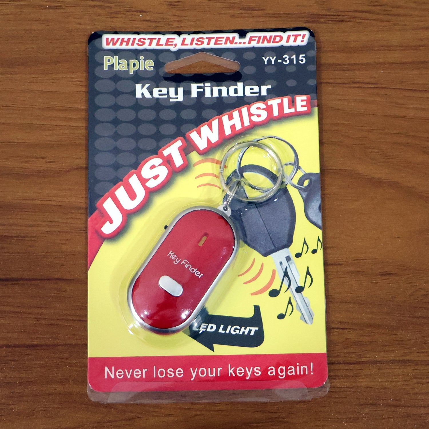 Hand holding the key finder with LED, demonstrating size and portability