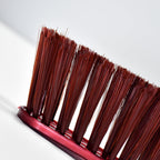 Velvet Wipe duster brush gently removing dust from a car dashboard.