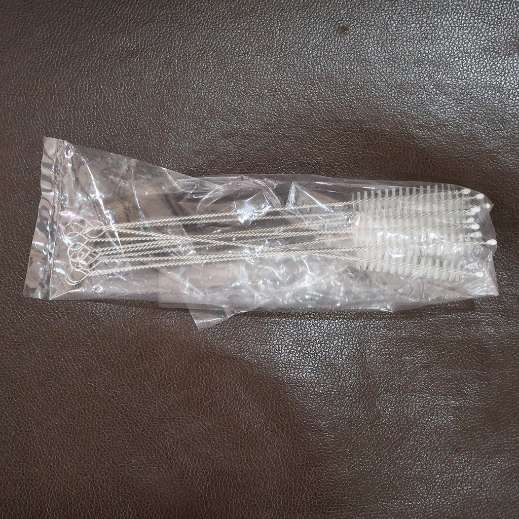 Straw and bottle cleaning brushes with loop handles arranged neatly on a surface
