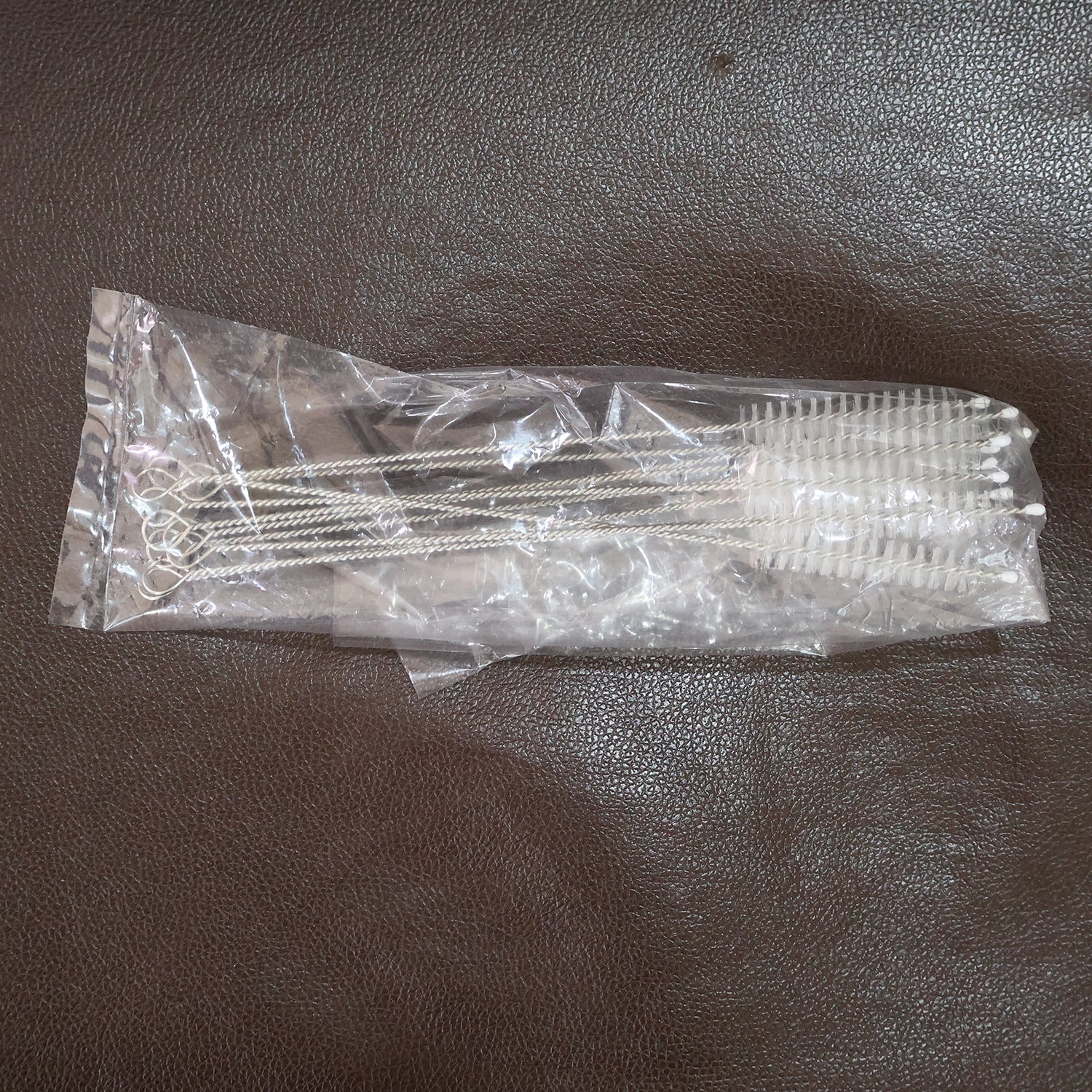 Straw and bottle cleaning brushes with loop handles arranged neatly on a surface