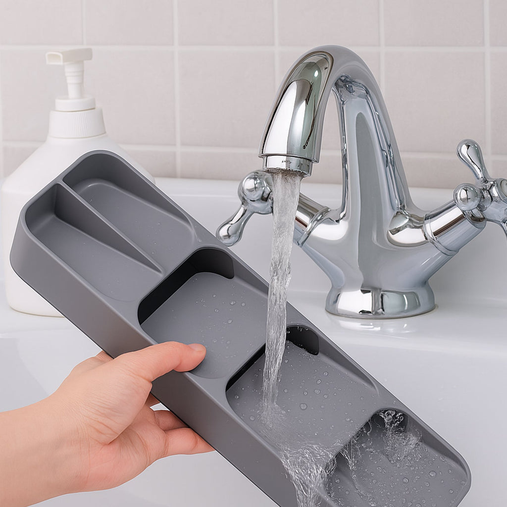 A hand placing a spoon into the organised compartment of the kitchen cutlery tray.