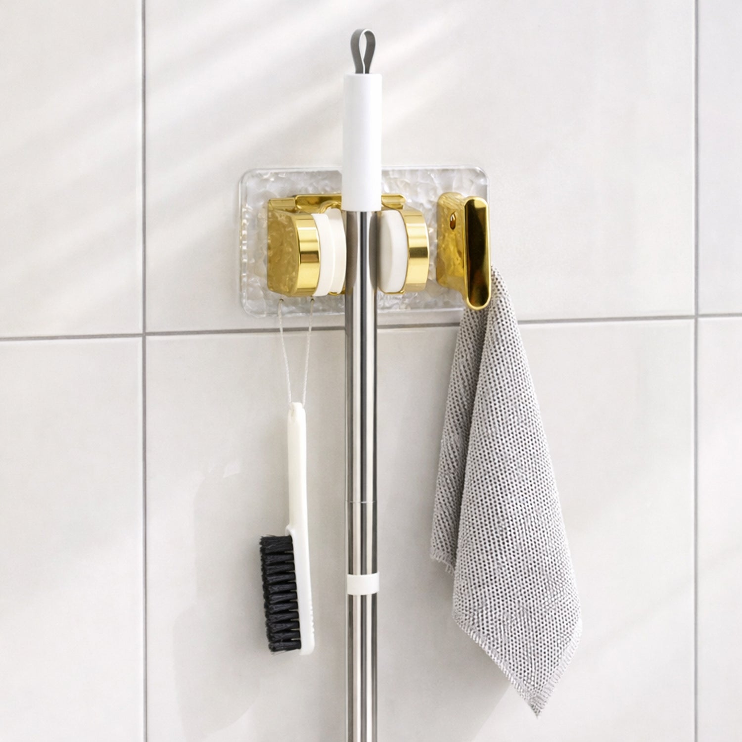 Space saving broom and mop hanger wall mounted with self adhesive base