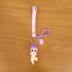 Detailed close-up of doll and cupcake charms on colorful rainbow strap keychain