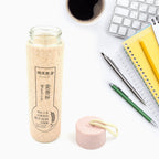 FERVENT glass water bottle placed on a wooden table in a contemporary setting.