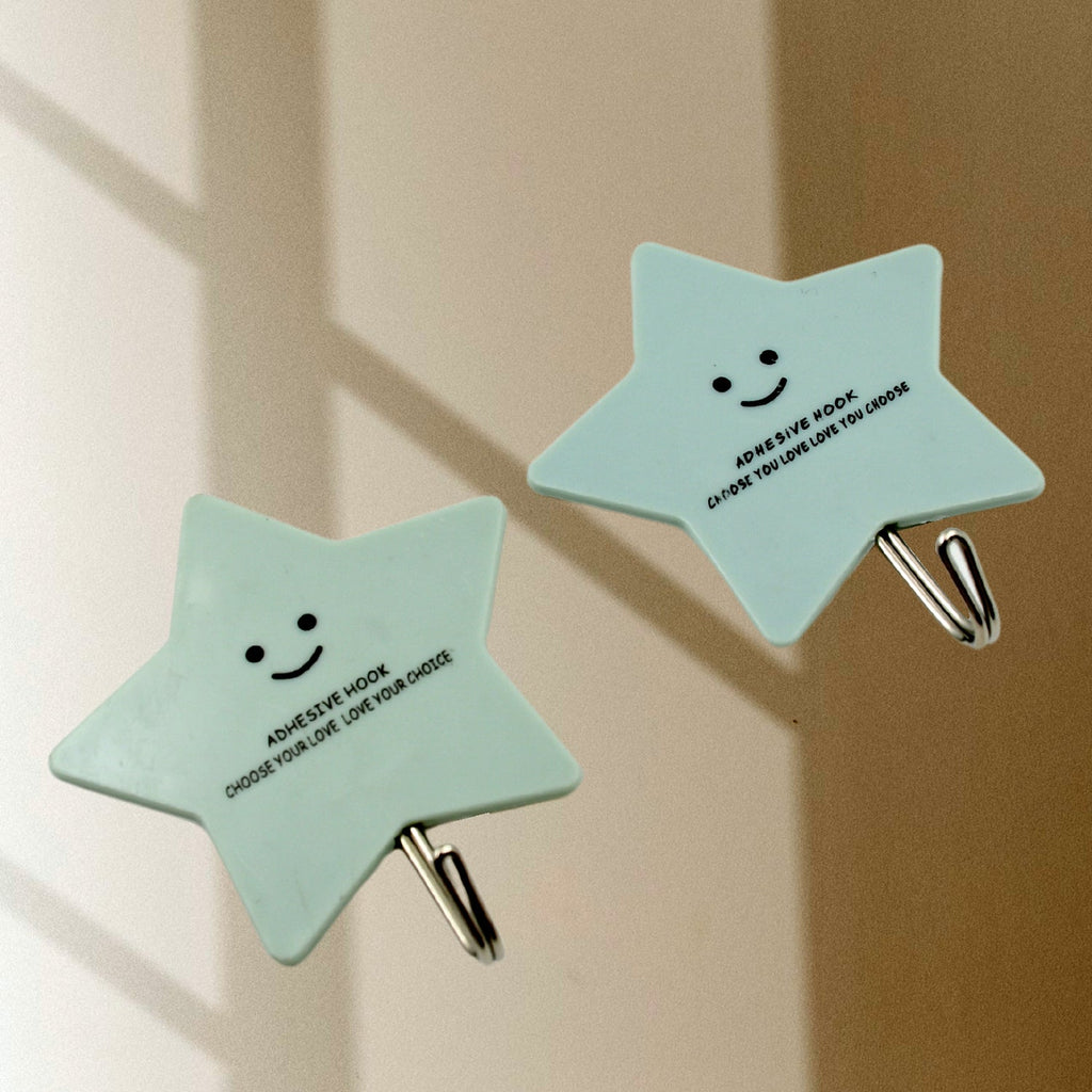 A kitchen scene demonstrating self-adhesive hooks holding spatulas and other cooking tools on a wall.