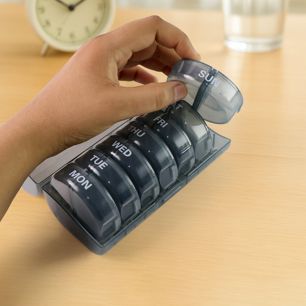 Hand holding the compact FERVENT travel pill case, highlighting its portability.